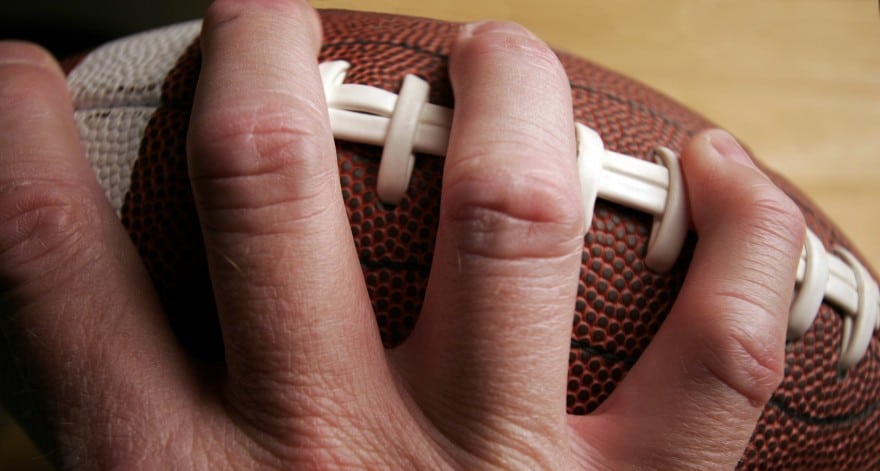Closeup of a hand holding an American football